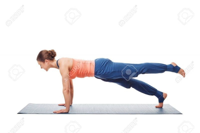 Woman doing Hatha yoga asana Utthita chaturanga dandasana Abheda Yoga